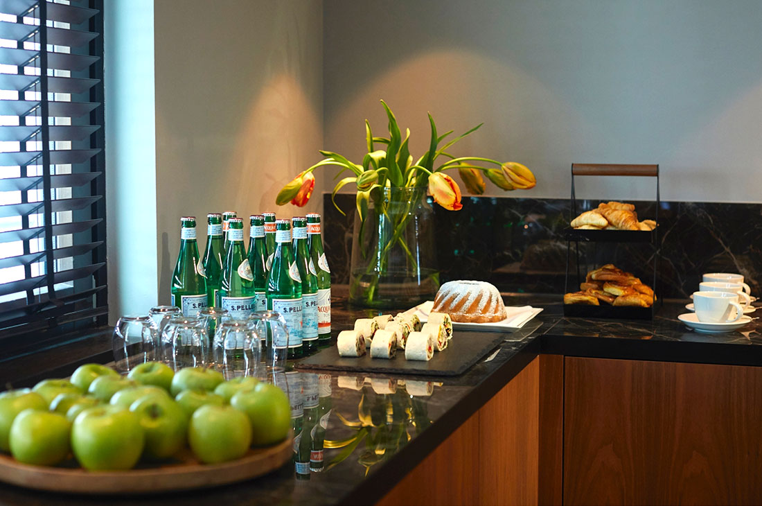 Kleines Buffet mit Wasser, Äpfel, Kuchen und Häppchen